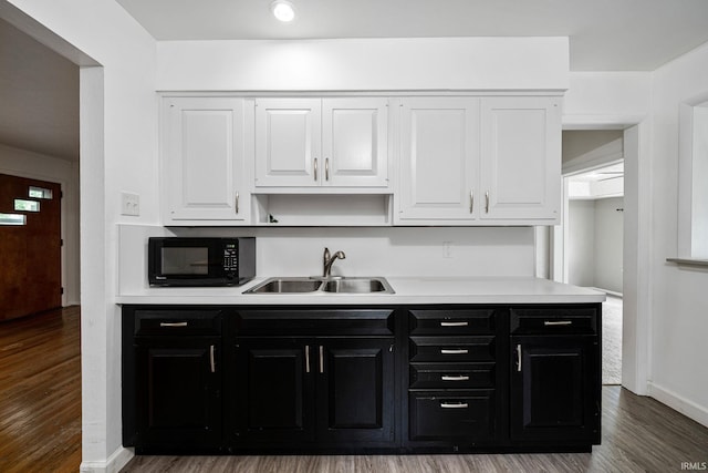 kitchen featuring sink, hardwood / wood-style flooring, and white cabinetry