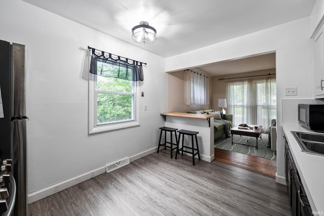 kitchen featuring sink, appliances with stainless steel finishes, hardwood / wood-style flooring, and white cabinetry