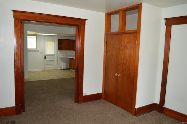 hall with carpet flooring and radiator heating unit