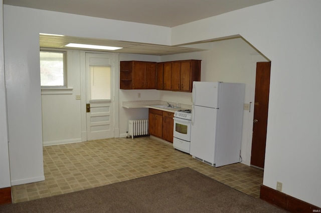 kitchen with radiator, sink, and white appliances