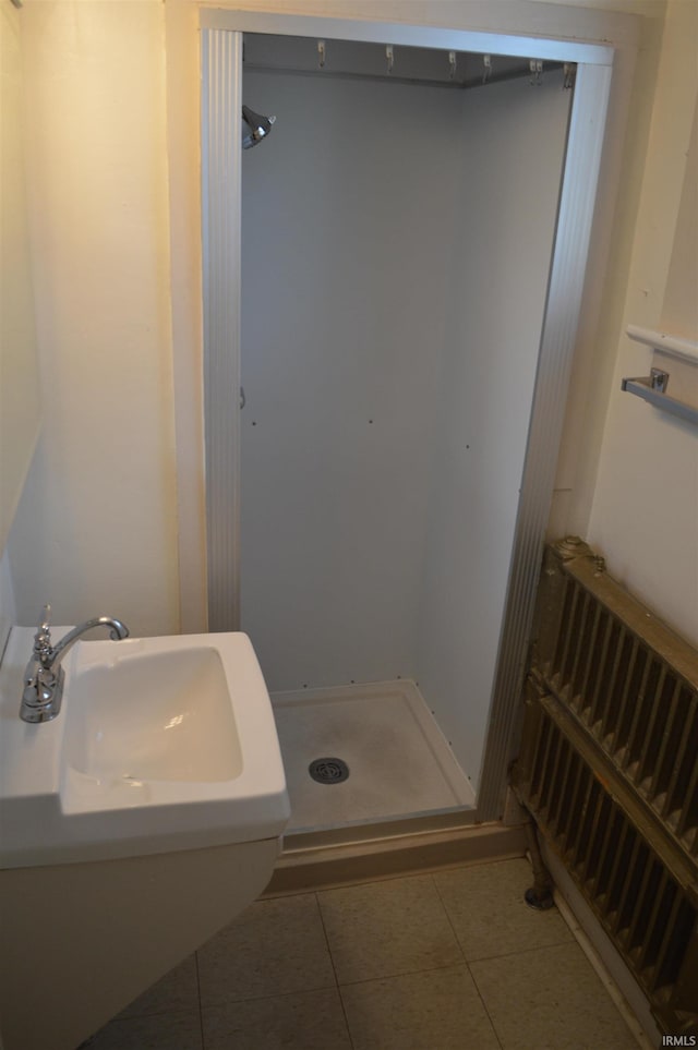 bathroom featuring tile patterned floors, radiator heating unit, and sink