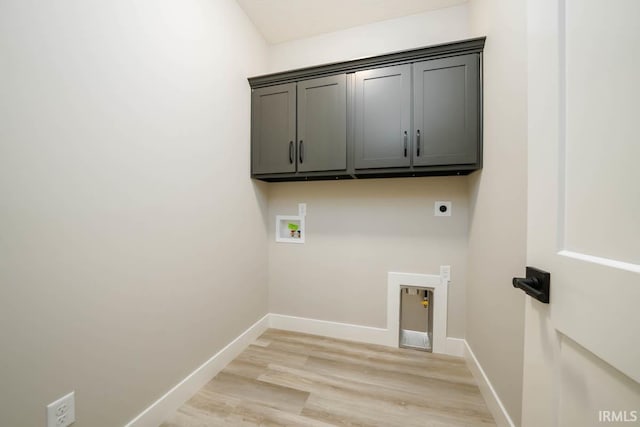 clothes washing area featuring hookup for an electric dryer, hookup for a washing machine, light hardwood / wood-style flooring, and cabinets