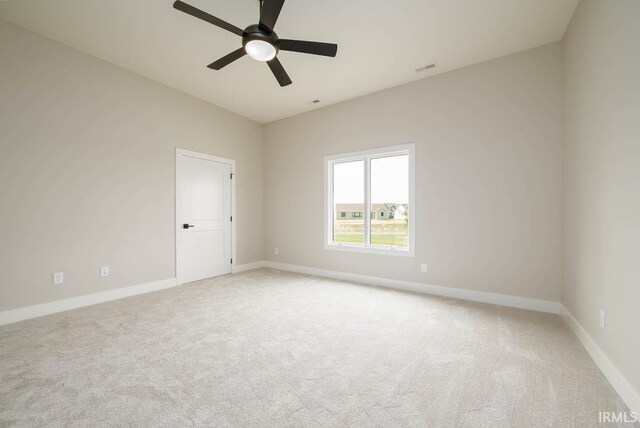 empty room with ceiling fan and light carpet