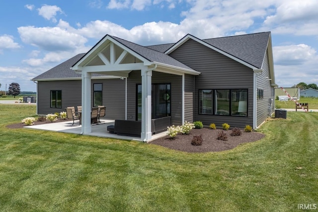 rear view of property featuring outdoor lounge area, a patio, central air condition unit, and a lawn