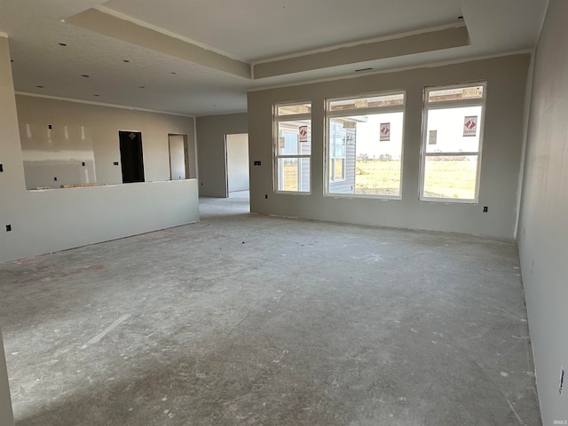 empty room with crown molding and a tray ceiling