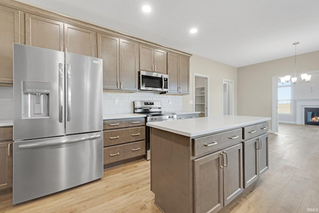 6711 W Division Line Rd, Delphi, IN 46923 - kitchen with light countertops, appliances with stainless steel finishes, light wood-type flooring, and a notable chandelier