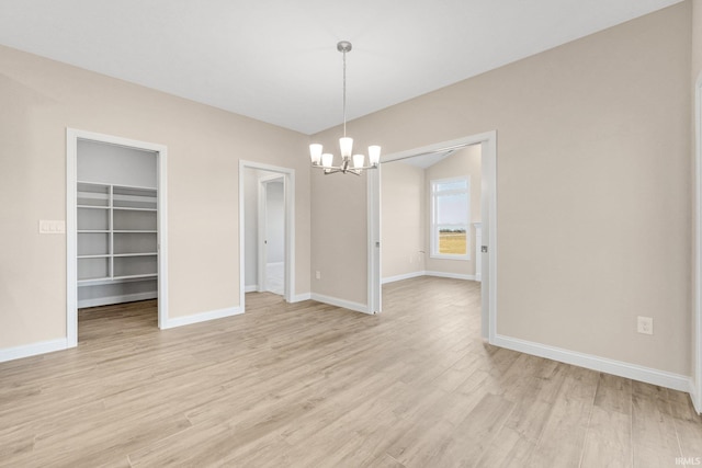 unfurnished dining area featuring a notable chandelier and light wood-type flooring