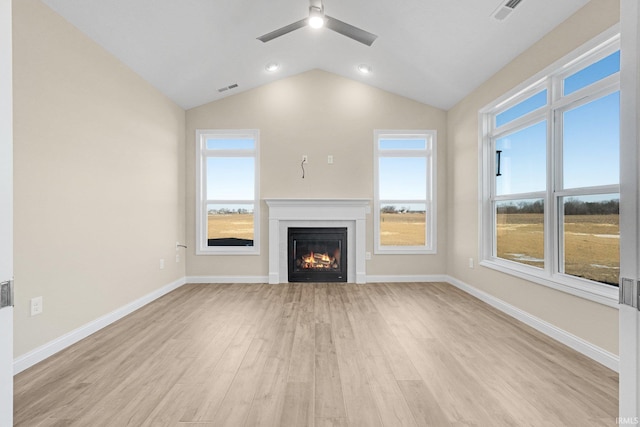 unfurnished living room featuring vaulted ceiling, light hardwood / wood-style floors, and ceiling fan