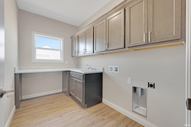 laundry area with sink, hookup for a washing machine, cabinets, hookup for an electric dryer, and light wood-type flooring