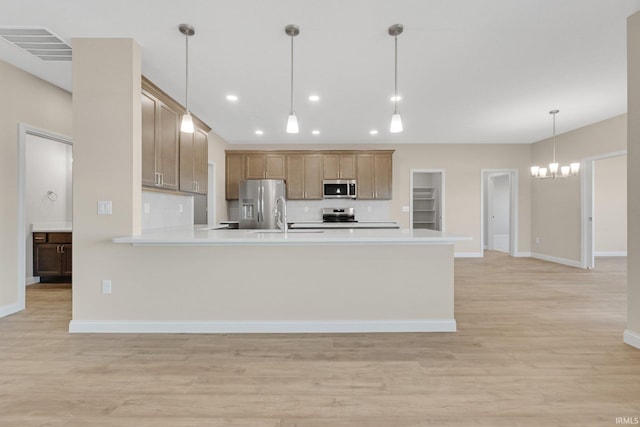 6711 W Division Line Rd, Delphi, IN 46923 - kitchen with a peninsula, baseboards, light wood-style floors, a notable chandelier, and stainless steel appliances