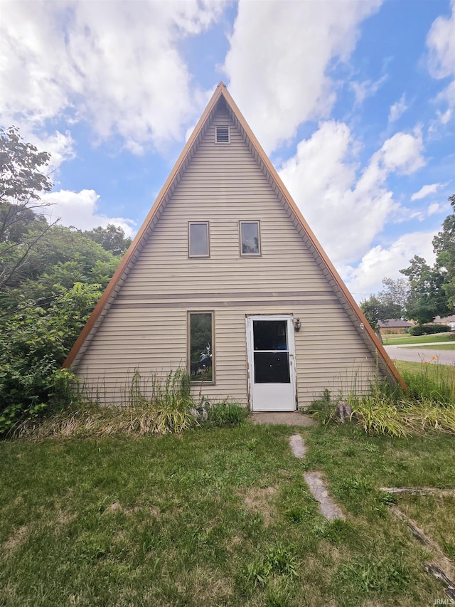 back of property with a lawn