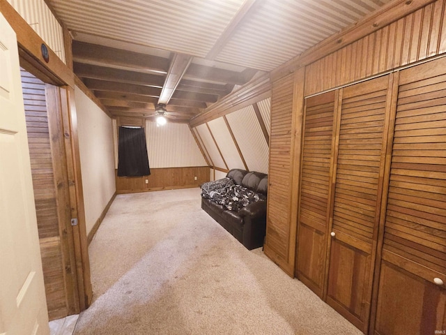 basement featuring ceiling fan, light colored carpet, and wooden walls