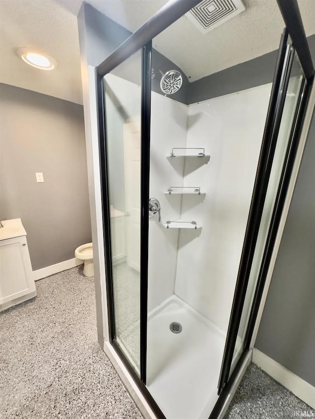 bathroom with toilet, walk in shower, and vanity