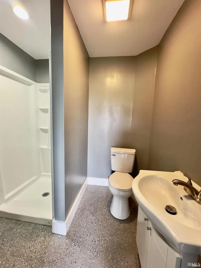 bathroom with toilet, vanity, and a shower