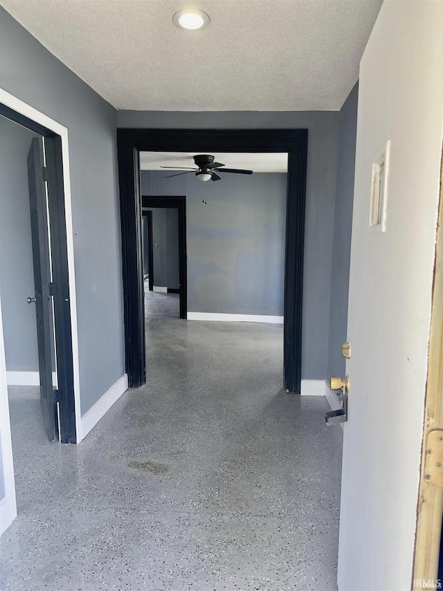 hall featuring a textured ceiling