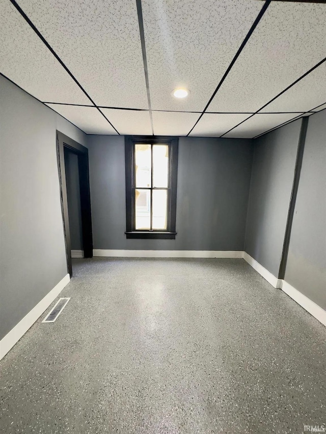 unfurnished room with a drop ceiling