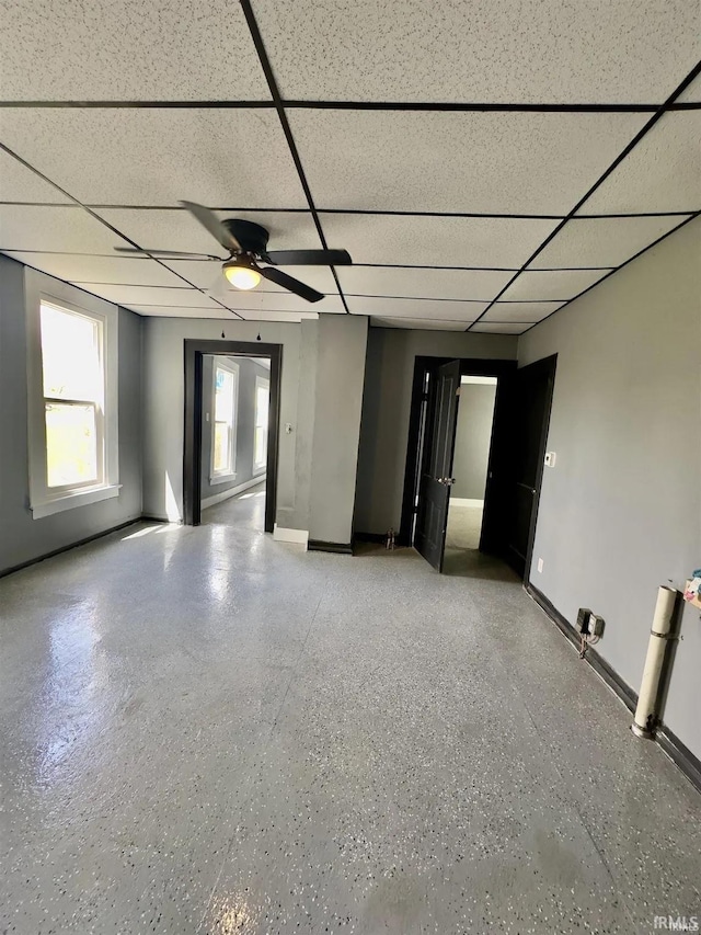 empty room featuring ceiling fan and a drop ceiling