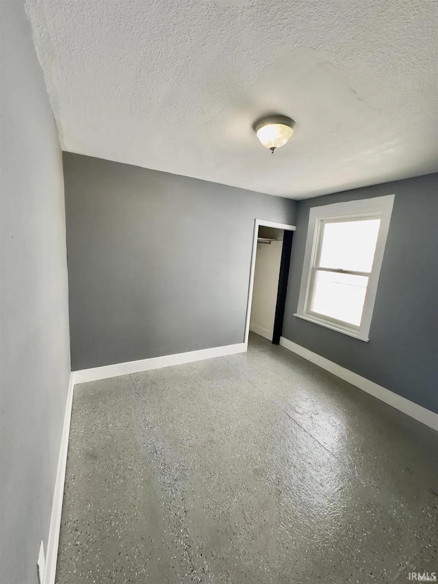 unfurnished bedroom with a closet and a textured ceiling