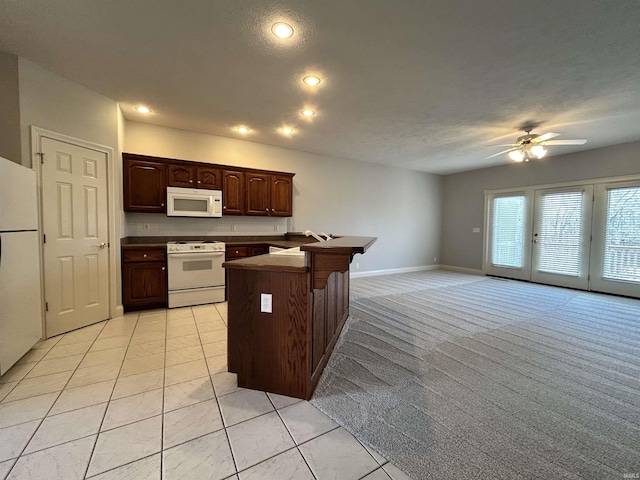 kitchen featuring ceiling fan, white appliances, light carpet, and a textured ceiling