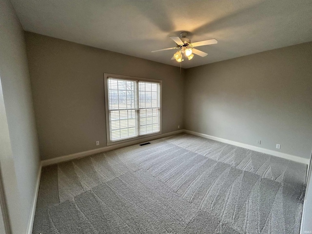 spare room with ceiling fan and carpet