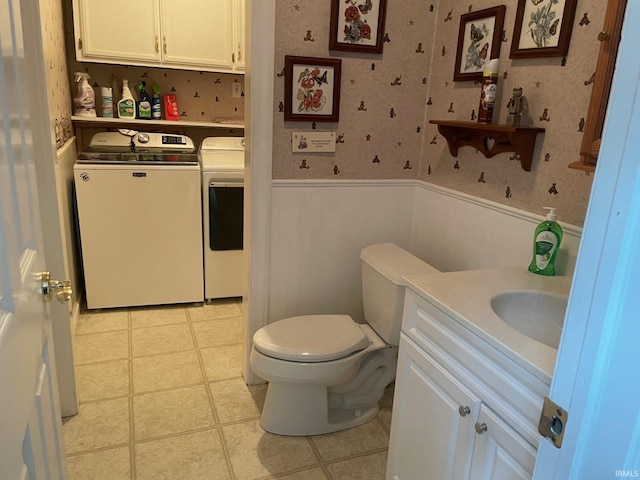 bathroom with washer and dryer, toilet, and vanity