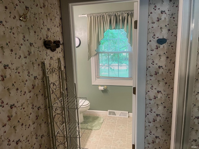 bathroom featuring walk in shower and toilet