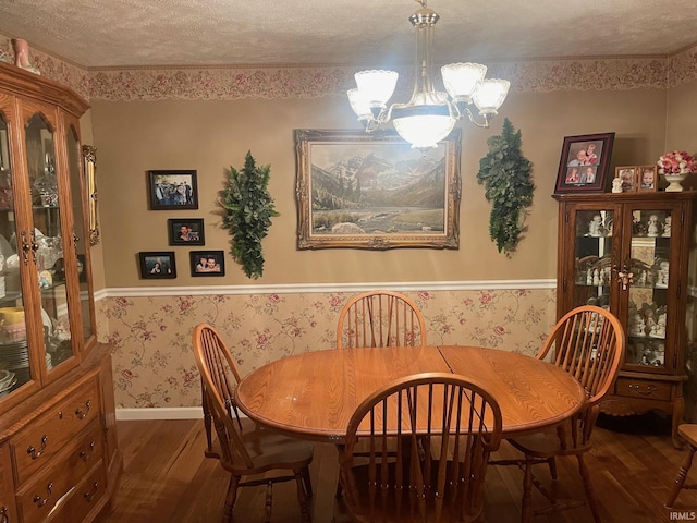 dining space featuring dark hardwood / wood-style floors, a textured ceiling, and a chandelier