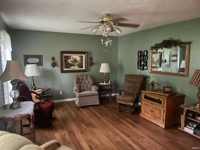 living area featuring dark hardwood / wood-style floors and ceiling fan