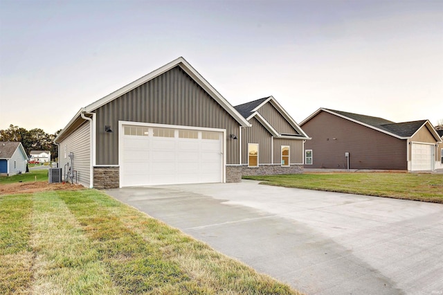 view of front facade with a front yard, a garage, and cooling unit