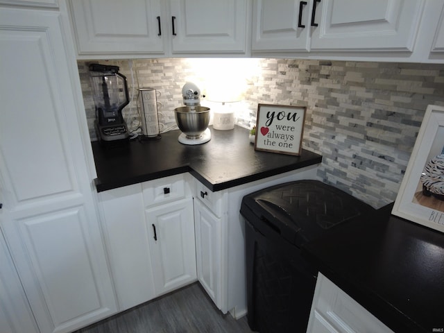 kitchen with white cabinetry, dark wood-type flooring, and tasteful backsplash