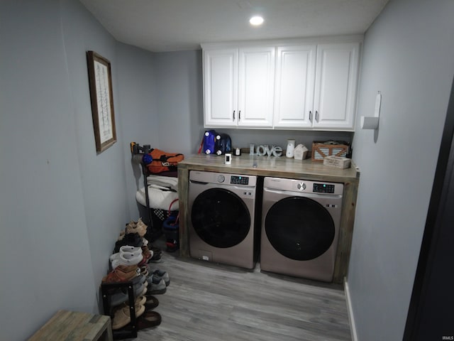 laundry area with cabinets, independent washer and dryer, and light wood-type flooring