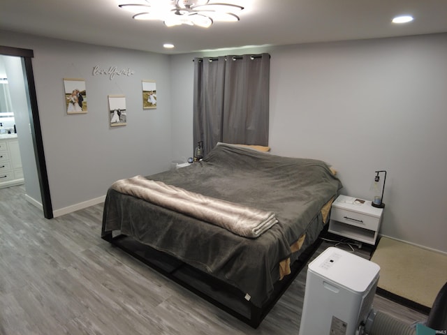 bedroom featuring hardwood / wood-style floors and ensuite bath