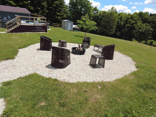 view of yard featuring a pool side deck, an outdoor fire pit, and a shed