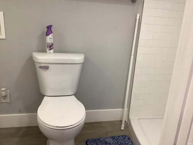 bathroom featuring a shower, hardwood / wood-style flooring, and toilet