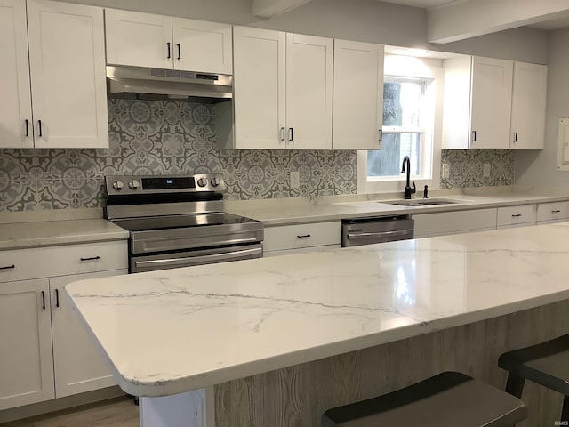 kitchen with white cabinets, stainless steel appliances, and a breakfast bar area