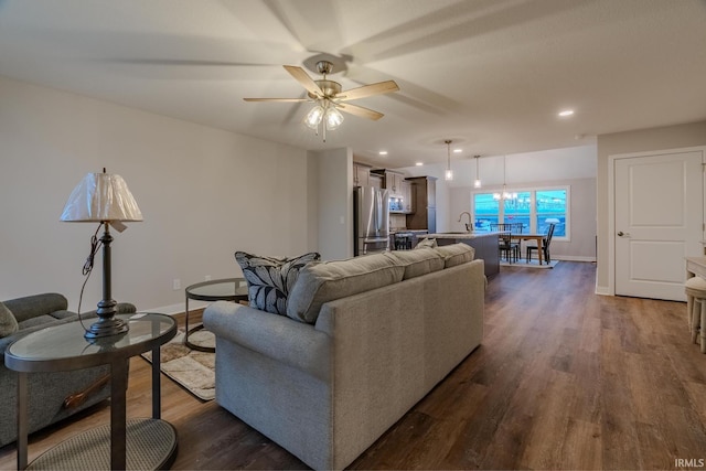living area featuring baseboards, a ceiling fan, dark wood-style floors, and recessed lighting