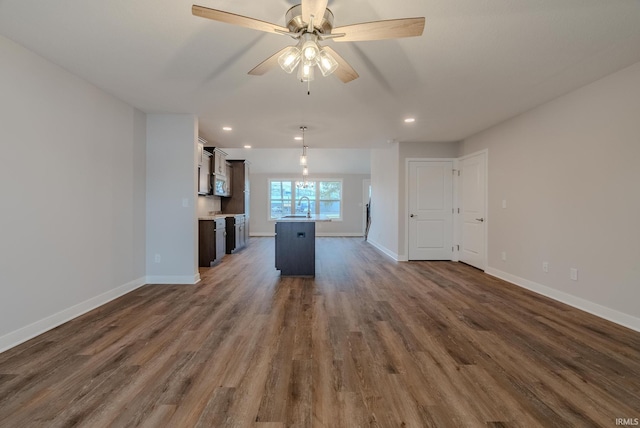 kitchen with ceiling fan, a center island, sink, dark wood-type flooring, and dark brown cabinets