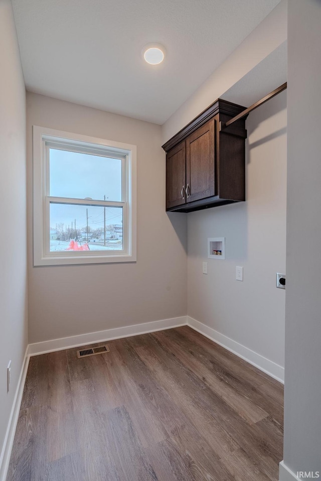 clothes washing area with cabinets, washer hookup, electric dryer hookup, and hardwood / wood-style floors