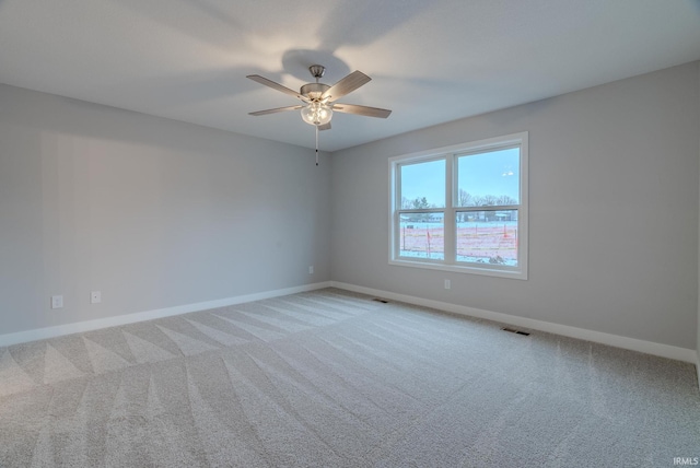 carpeted spare room featuring ceiling fan