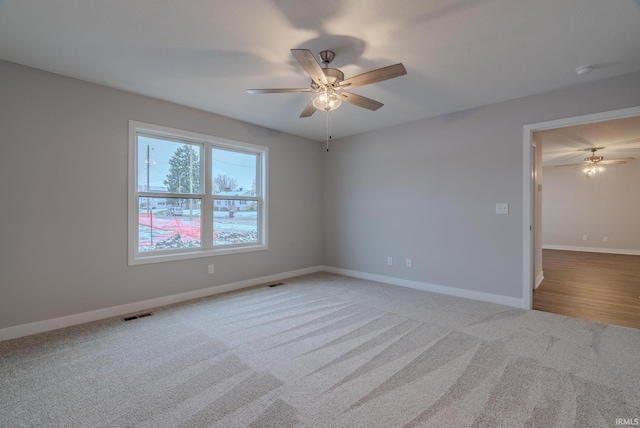 carpeted spare room with ceiling fan