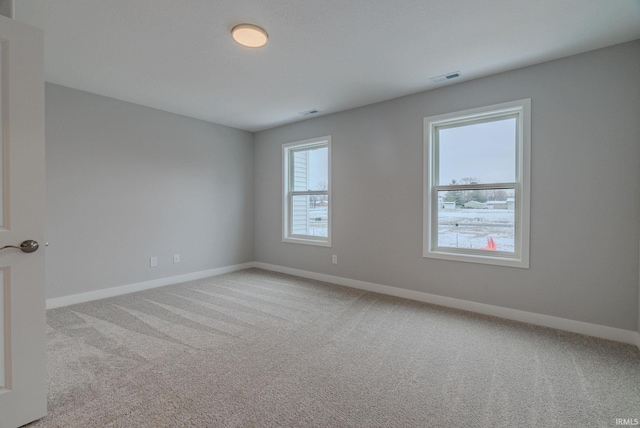 spare room featuring light colored carpet