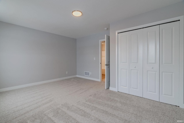 unfurnished bedroom featuring light colored carpet and a closet