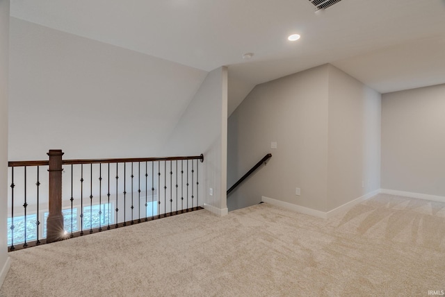 additional living space featuring light colored carpet and vaulted ceiling