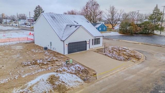 view of snow covered exterior featuring central AC and driveway