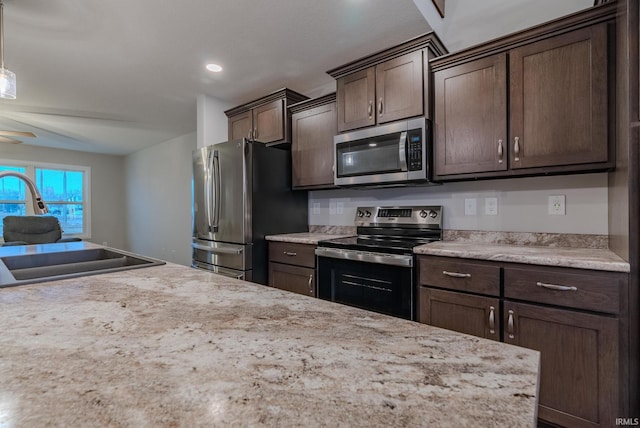 kitchen with stainless steel appliances, a sink, dark brown cabinets, recessed lighting, and a ceiling fan