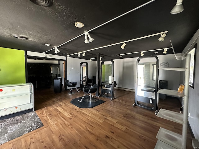 gym featuring wood-type flooring and rail lighting