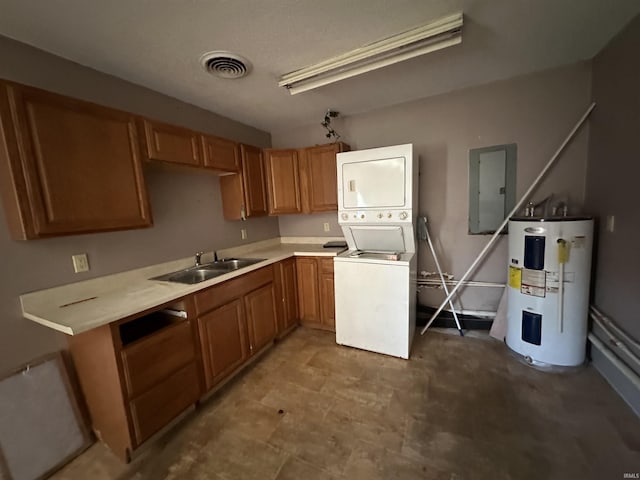 kitchen featuring electric panel, sink, stacked washing maching and dryer, water heater, and kitchen peninsula