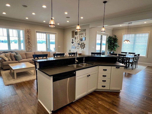 kitchen featuring sink, stainless steel dishwasher, an island with sink, decorative light fixtures, and white cabinetry