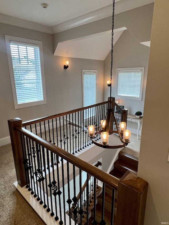 stairs with a chandelier, carpet, crown molding, and lofted ceiling