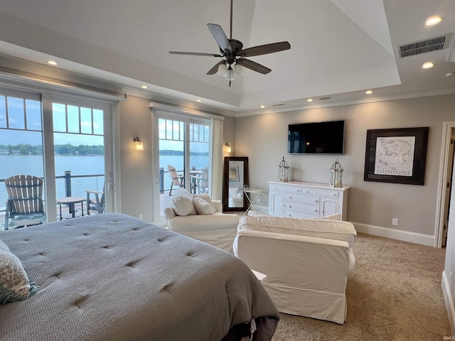 carpeted bedroom with access to outside, a raised ceiling, ceiling fan, and a water view